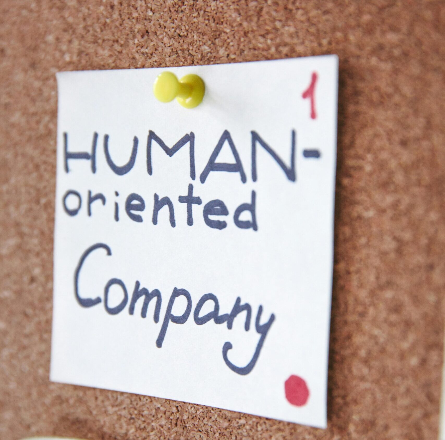 Handwritten notes on a corkboard illustrating a human-oriented company concept. Ideal for business innovation themes.